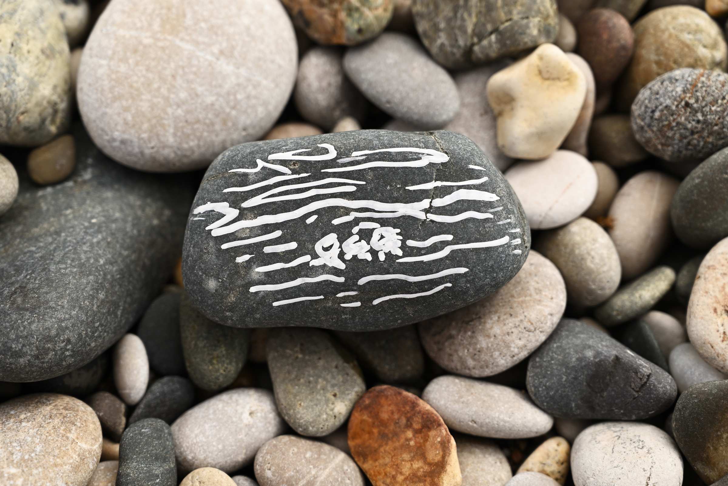 Рисунок маркером на камне на пляже в Новом Афоне.